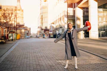 middle-aged happy woman with a heart-shaped balloon falling a love, having a fun day, walking around English city Spring is in the air Lifestyle, tourism, valentines day, world woman's day concept