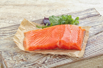 Raw salmon fillet over board