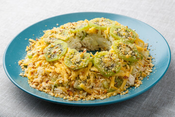 Salad with kiwi chicken and nuts on the table on a white tablecloth close-up