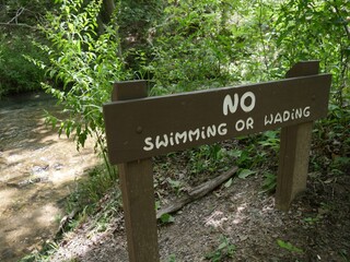 Wooden sign warning of no swimming or wading at Chickasaw National Recreation Area, Sulfur, Oklahoma.