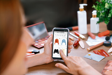 Woman shopping online on internet marketplace browsing for sale items for modern lifestyle and use credit card for online payment from wallet protected by utmost cyber security software - obrazy, fototapety, plakaty