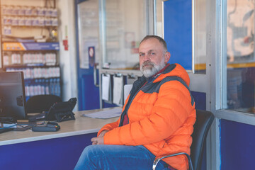 A man waiting at the garage for his car to be serviced and winter tires fitted ahead of the winter season