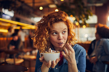 Happy woman eating dessert in a cafe