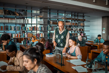 Professor assisting multiethnic students in library