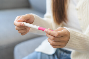 Sad, Disappointed motherhood asian young woman hand holding pregnancy test, upset ovulation...
