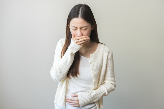 Unhappy pregnant asian young woman, pain girl suffering from nausea, having vomit feeling sick covering mouth, touching belly having problem throwing up from food poisoning, lady with morning sickness