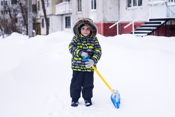 Fototapeta premium child on a walk in winter in cold snowy weather in an urban environment