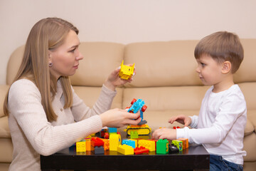 Obraz na płótnie Canvas woman plays with a child using a construction set