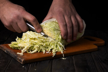 Cutting vegetables. Male hands cutting cabbage on a cutting board.