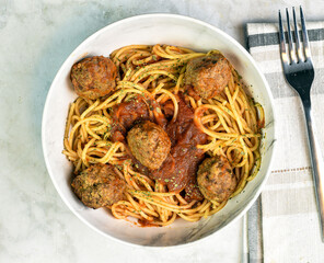 spaghetti top with parsley , sauce and meat balls
