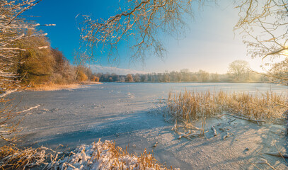 Winter wonderland. Frozen river framed of snow-covered trees, hoarfrost on branches. Clear sunrise blue sky. Idyllic landscape. Nature seasons climate change, ecology, ecotourism. Christmas vacations © icemanphotos