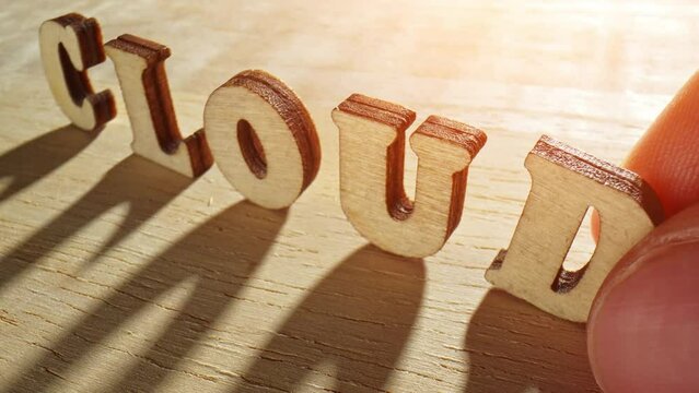 Captivating close-up: Watch skilled fingers meticulously arrange wooden letters into the word "Cloud" using a probe lens 24mm. Dynamic dolly slide.

