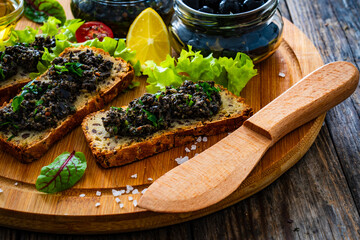 Tasty bruschetta with tapenade on wooden table
