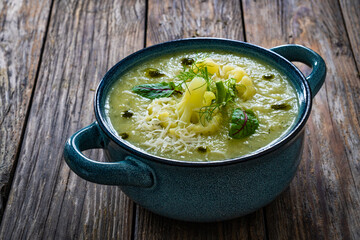 Cauliflower cream soup on wooden table
