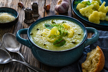 Cauliflower cream soup on wooden table
