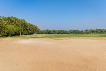 isolated green playing ground with bright blue sky at day from flat angle