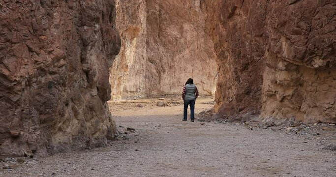Death Valley female wife hiking narrow slot canyon. Largest national park in contiguous USA. 282 feet below sea level. Mojave Desert bordering Great Basin Desert. Ecological geology. 