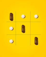 Creative photo of tablets on a yellow background. The tablets lie in the form of a tic-tac-toe game.