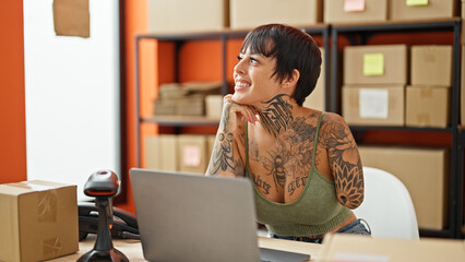 Hispanic woman with amputee arm ecommerce business worker using laptop thinking at office