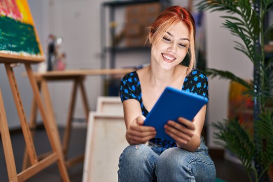 Young caucasian woman artist smiling confident using touchpad at art studio