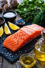 Fresh raw salmon steak with fresh vegetables on wooden background
