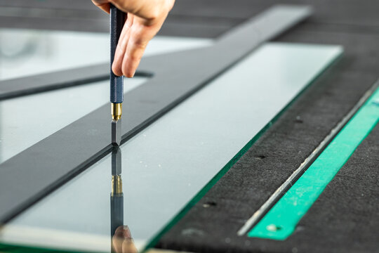 A glazier cuts thick glass on a specialized table, Concept, Glass work