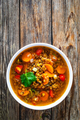 Fresh vegetable soup with lentil on wooden table

