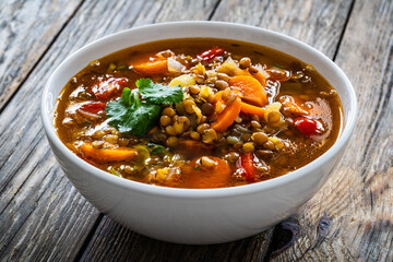 Fresh vegetable soup with lentil on wooden table

