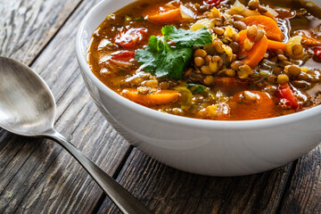 Fresh vegetable soup with lentil on wooden table

