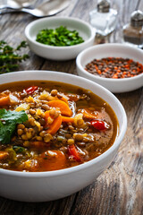 Fresh vegetable soup with lentil on wooden table

