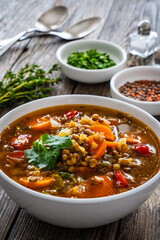 Fresh vegetable soup with lentil on wooden table

