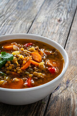 Fresh vegetable soup with lentil on wooden table

