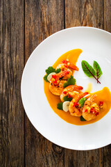 Shrimps salad with ginger and chili in mango sauce on wooden table
