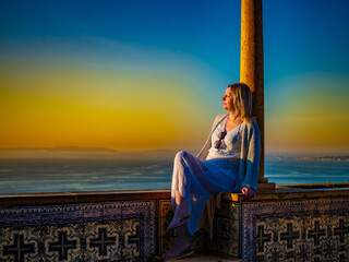 Woman sitting at Santa Luzia viewpoint in Lisbon
