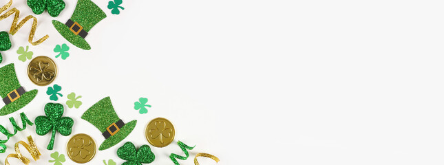 St Patricks Day corner border of green shamrocks, leprechaun hats, gold coins and ribbon. Overhead view over a white banner background with copy space. - obrazy, fototapety, plakaty