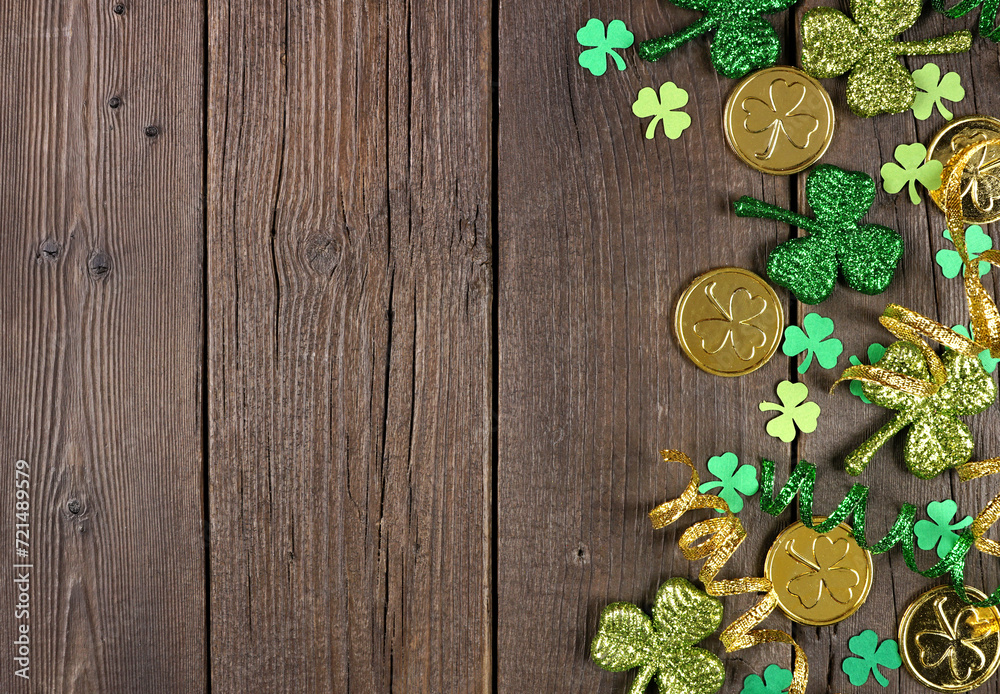 Poster st patricks day side border of green shamrocks, gold coins and ribbon. top view over a rustic dark w