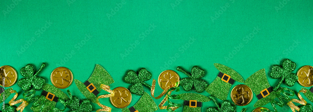 Poster st patricks day bottom border of shamrocks, leprechaun hats, gold coins and ribbon. top view over a 