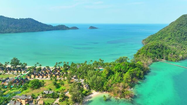 Captivating drone shot unveils the idyllic blend of lush, emerald coastline and crystal-clear tropical waters. Adventure tourism concept. Sea stock footage. Ko Chang island, Thailand. 4K HDR.
