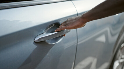 African american man opening car door at street