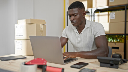 African american man ecommerce business worker typing on laptop at office