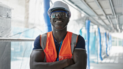African american man builder smiling confident standing with arms crossed gesture at construction...