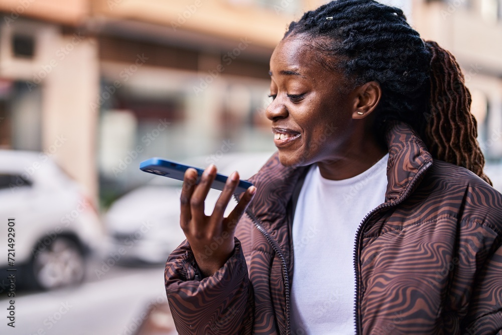 Wall mural African american woman smiling confident talking on the smartphone at street