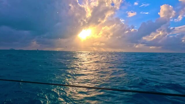 Navegando el mar caribe mexicano en un yate al atardecer con cielo semi nublado