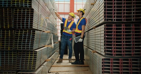 Workers partners in uniform safety and hardhat holding tablet Talking on a Meeting in Metal Construction Manufacture industry factory, Engineers man industrial discussing project work. Team work