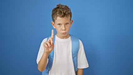 Adorable blond boy student, a smart little kid standing, serious face expressing negation, saying...