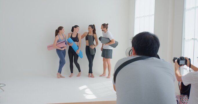 Photographer Taking Photos group of yoga students standing leaned on wall at yoga class, people in sportswear holds yoga mats looking happy and healthy, well-being, sports wellness concept