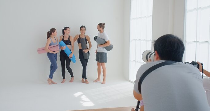 Photographer Taking Photos group of yoga students standing leaned on wall at yoga class, people in sportswear holds yoga mats looking happy and healthy, well-being, sports wellness concept