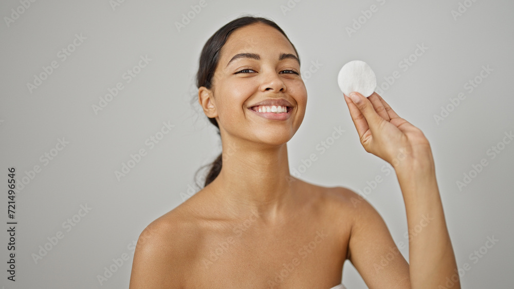 Sticker African american woman smiling confident holding cotton pad smiling over isolated white background