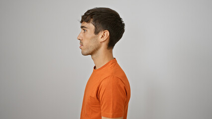 Attractive young hispanic man in deep concentration, standing relaxed, eyes looking away to the...
