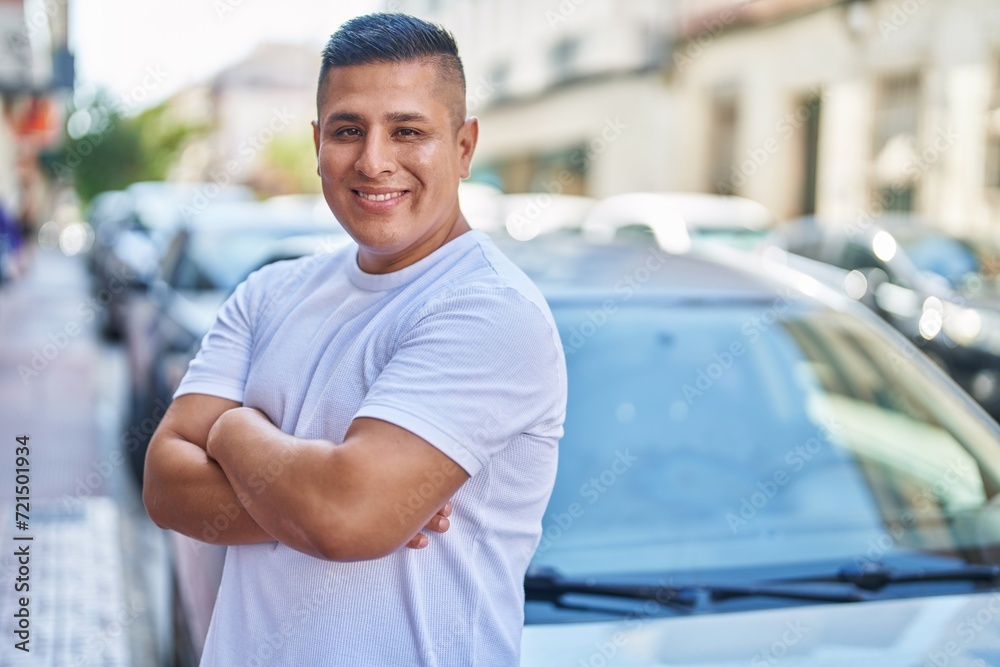 Sticker Young latin man smiling confident standing with arms crossed gesture at street